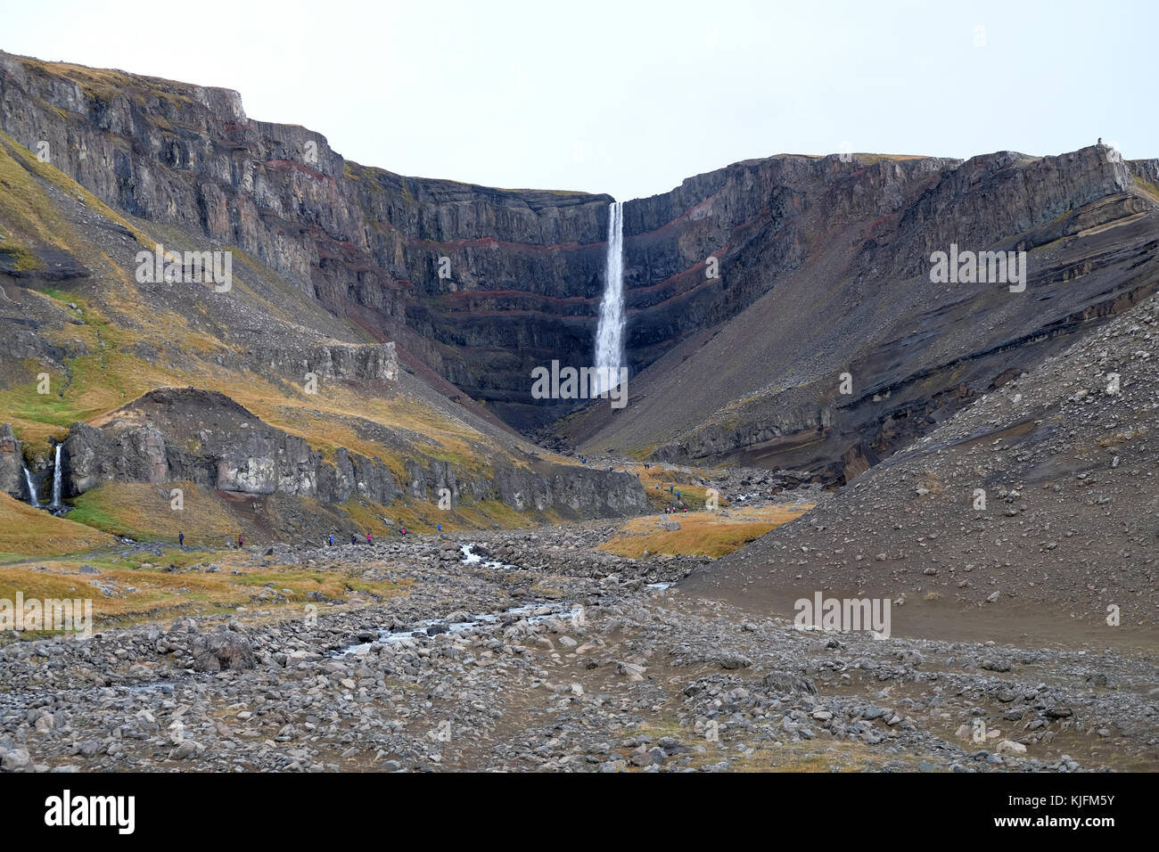 Wanderer und Trekker wandern an der Basis der hengifoss Wasserfall bergige Landschaft in eastfjords, egilsstadir Osten Islands Stockfoto