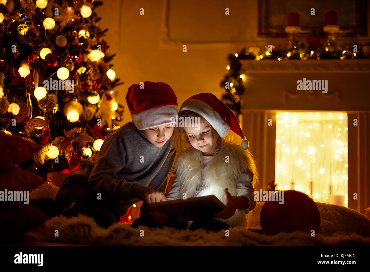 Aufgeregte Kinder in der Nähe von Weihnachten Baum Stockfoto