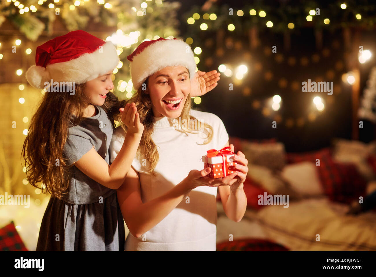 Mutter und Tochter in santa Hüte Geschenke in einem Zimmer in Ch Stockfoto