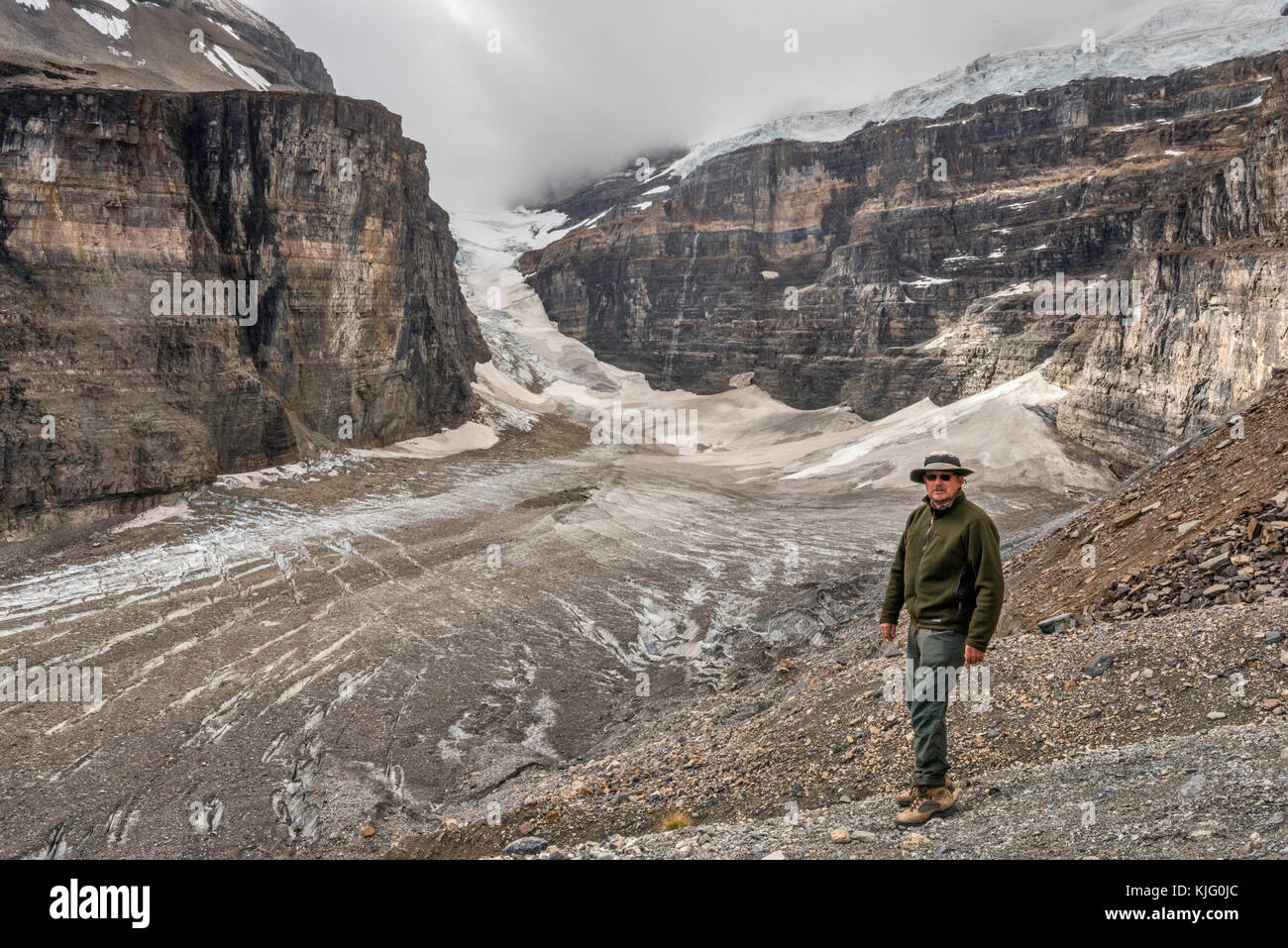 Wanderer auf schroffen Hängen über dem Lower Victoria Glacier, Mt Lefroy, Mt Victoria in Clouds in dist, Banff National Park, Alberta, Kanada Stockfoto