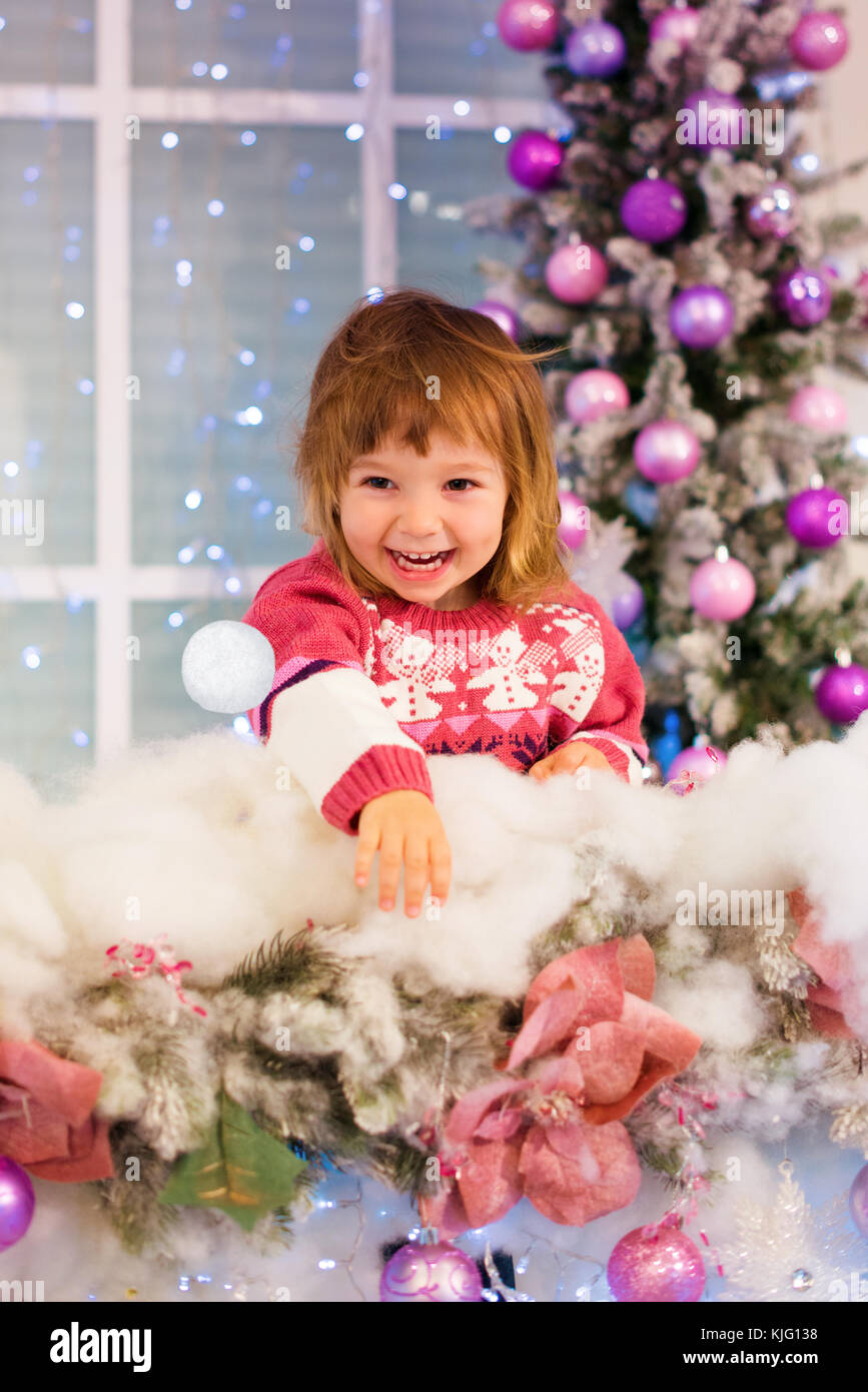 Happy Baby Mädchen spielen mit Schneebällen im Zimmer. Das Mädchen wirft einen Schneeball Stockfoto