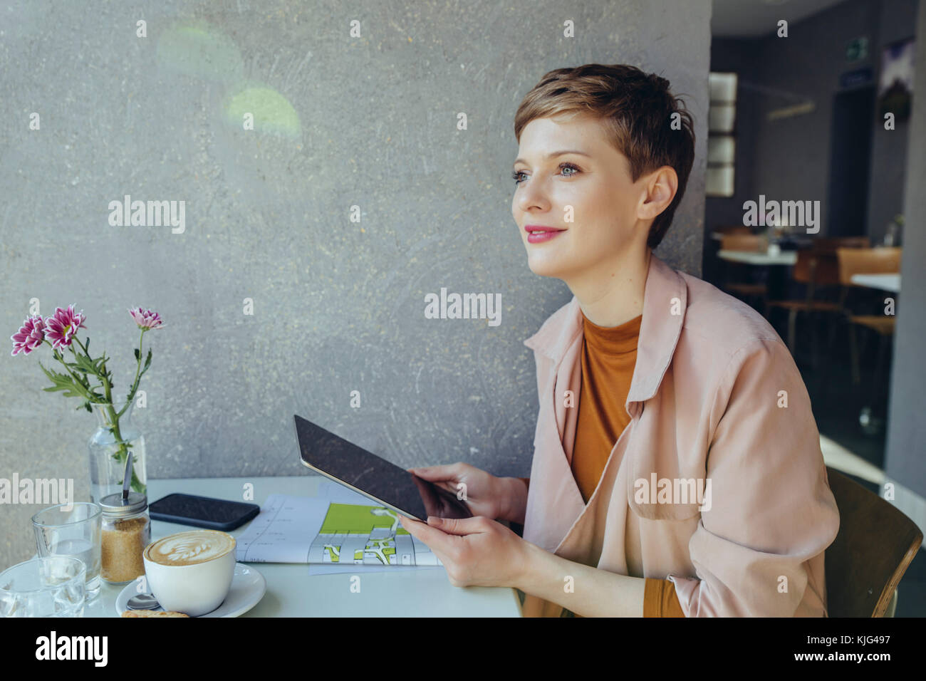 Frau mit einer Tablette in ein Cafe seitlich auf der Suche Stockfoto