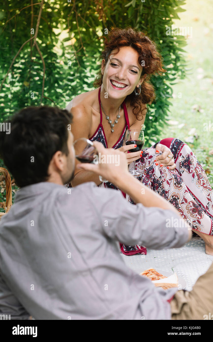 Paar bei einem Picknick im Park trinken Rotwein Stockfoto