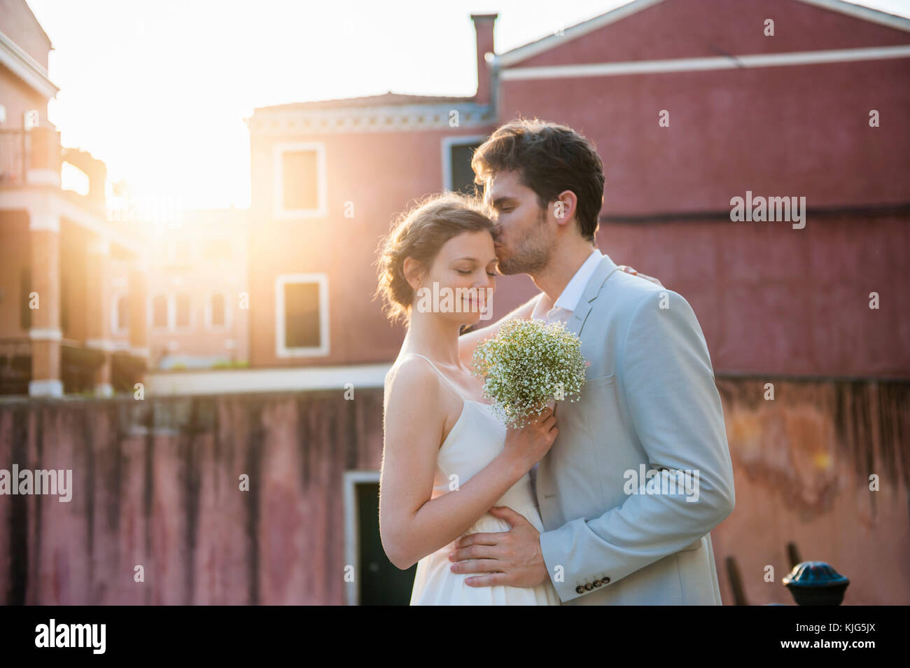 Italien, Venedig, Bräutigam Braut küssen bei Sonnenaufgang Stockfoto
