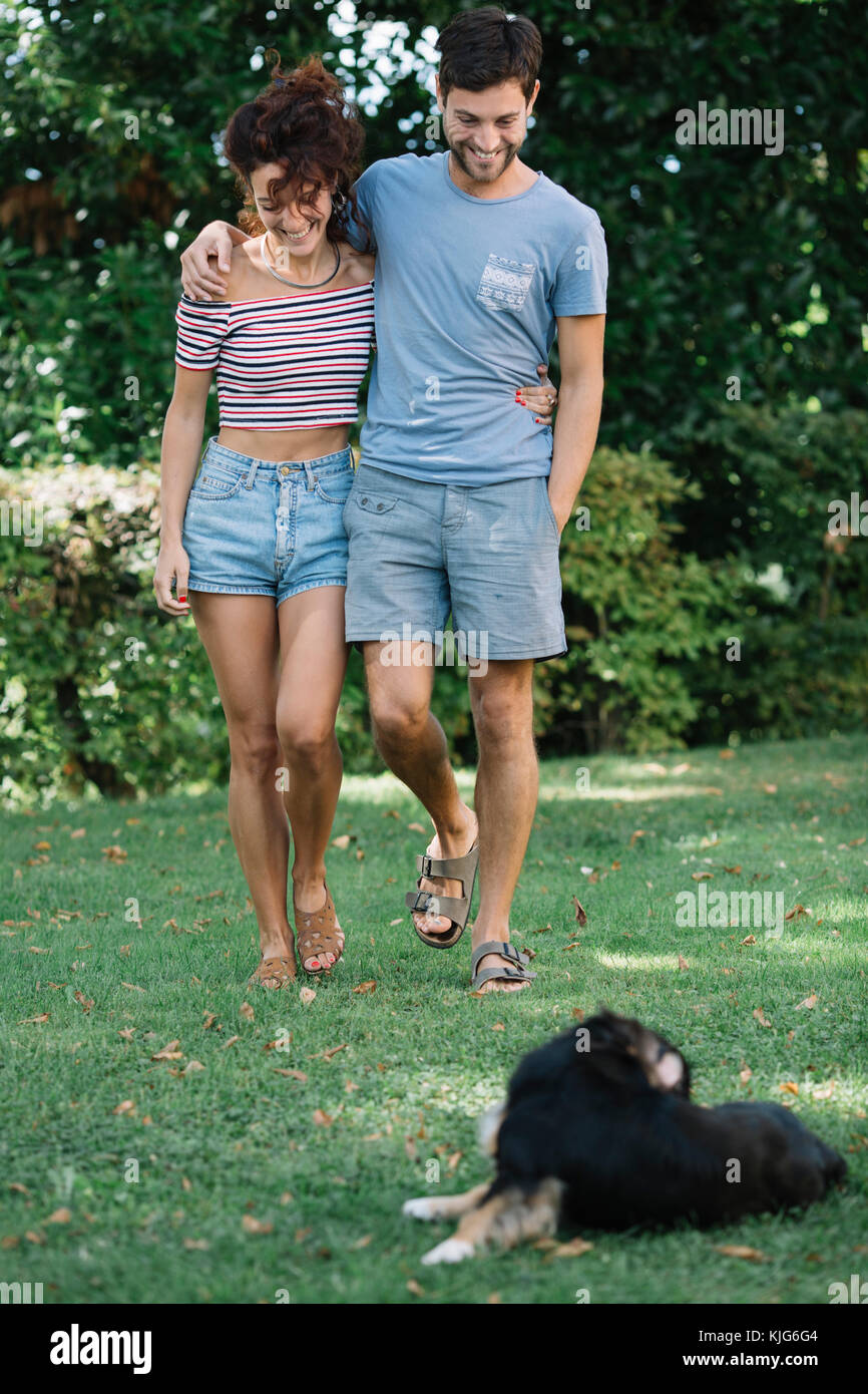 Verliebtes Paar mit Hund wandern in einem Park Stockfoto