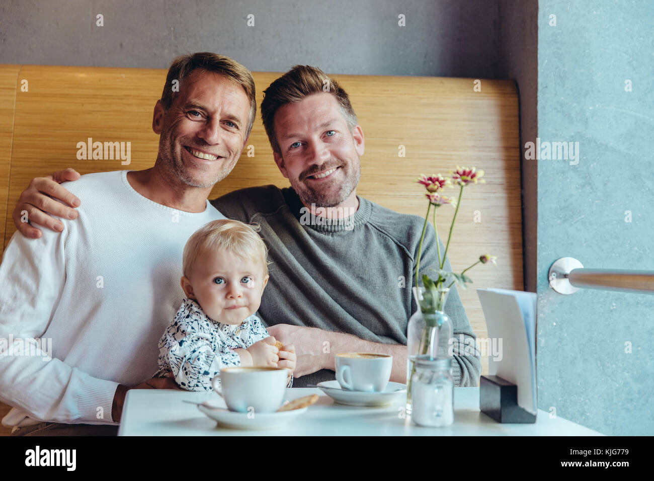 Portrait von Happy homosexuelles Paar mit ihrem Baby im Cafe Stockfoto