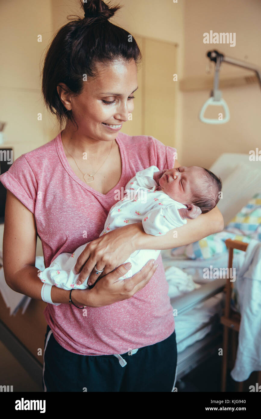 Glückliche Mutter ihr neugeborenes Baby Holding im Krankenhaus Stockfoto