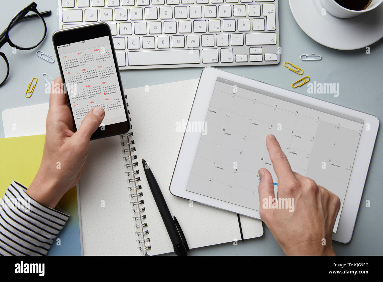 Blick von oben auf die Frau mit Smartphone und Tablet mit dem Kalender auf dem Schreibtisch Stockfoto