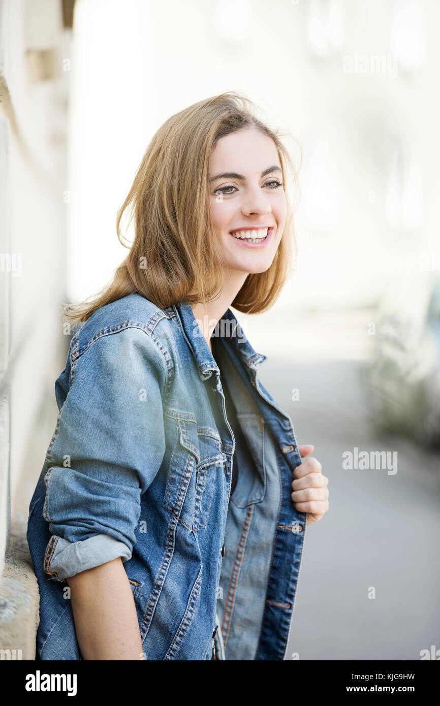 Portrait von lächelnden jungen Frau vor dem Haus Fassade Stockfoto