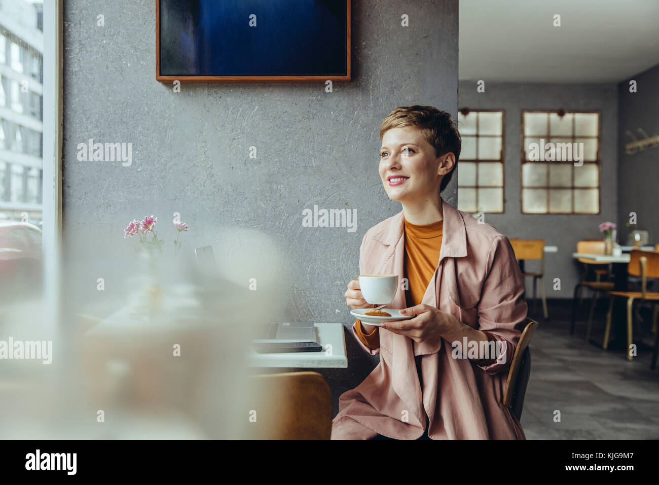 Frau mit ihrem Laptop genießen eine Tasse Kaffee in einem Cafe Stockfoto