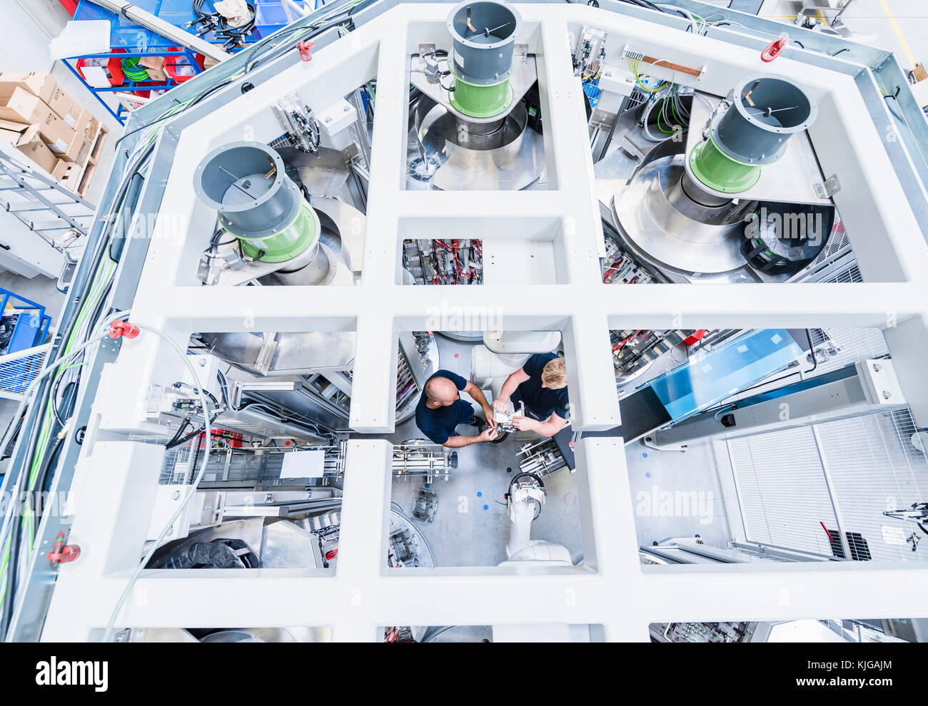 Blick von oben auf die beiden Kollegen an Industrieroboter in der modernen Fabrik arbeiten Stockfoto