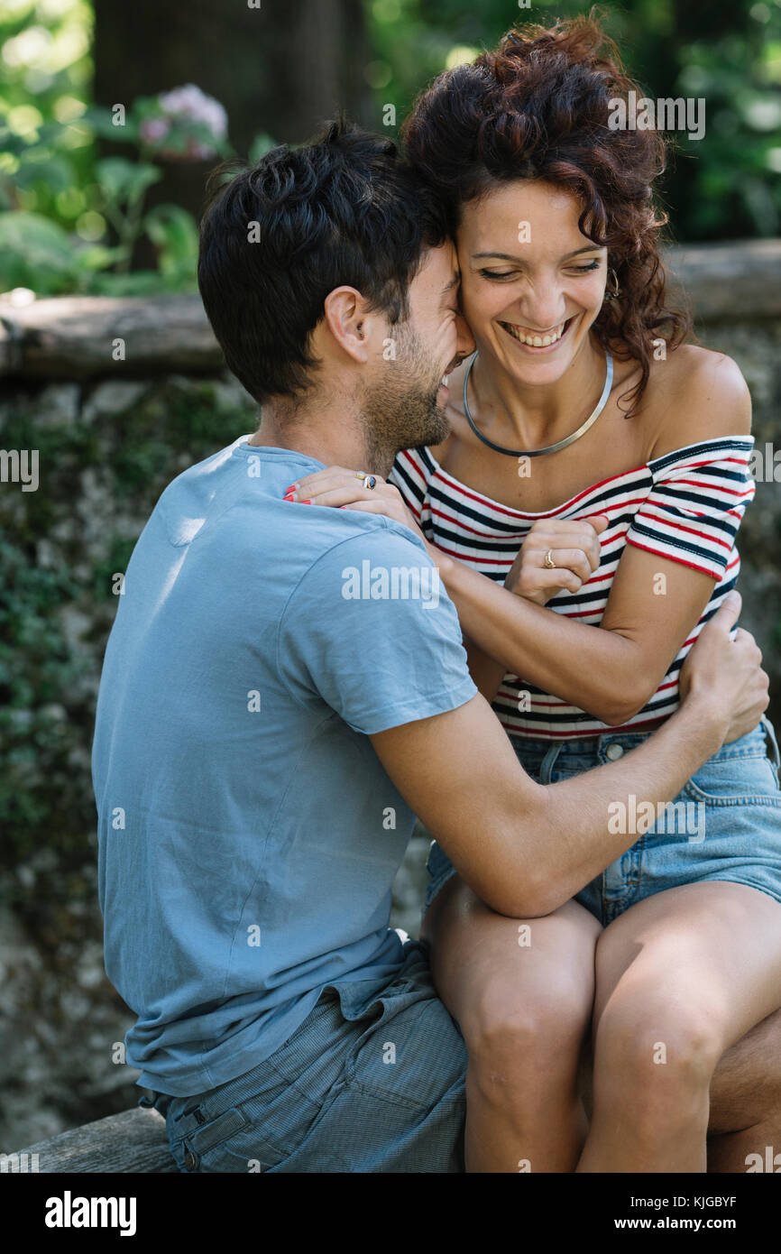Paar in Liebe umarmen auf der Werkbank in einem Park Stockfoto