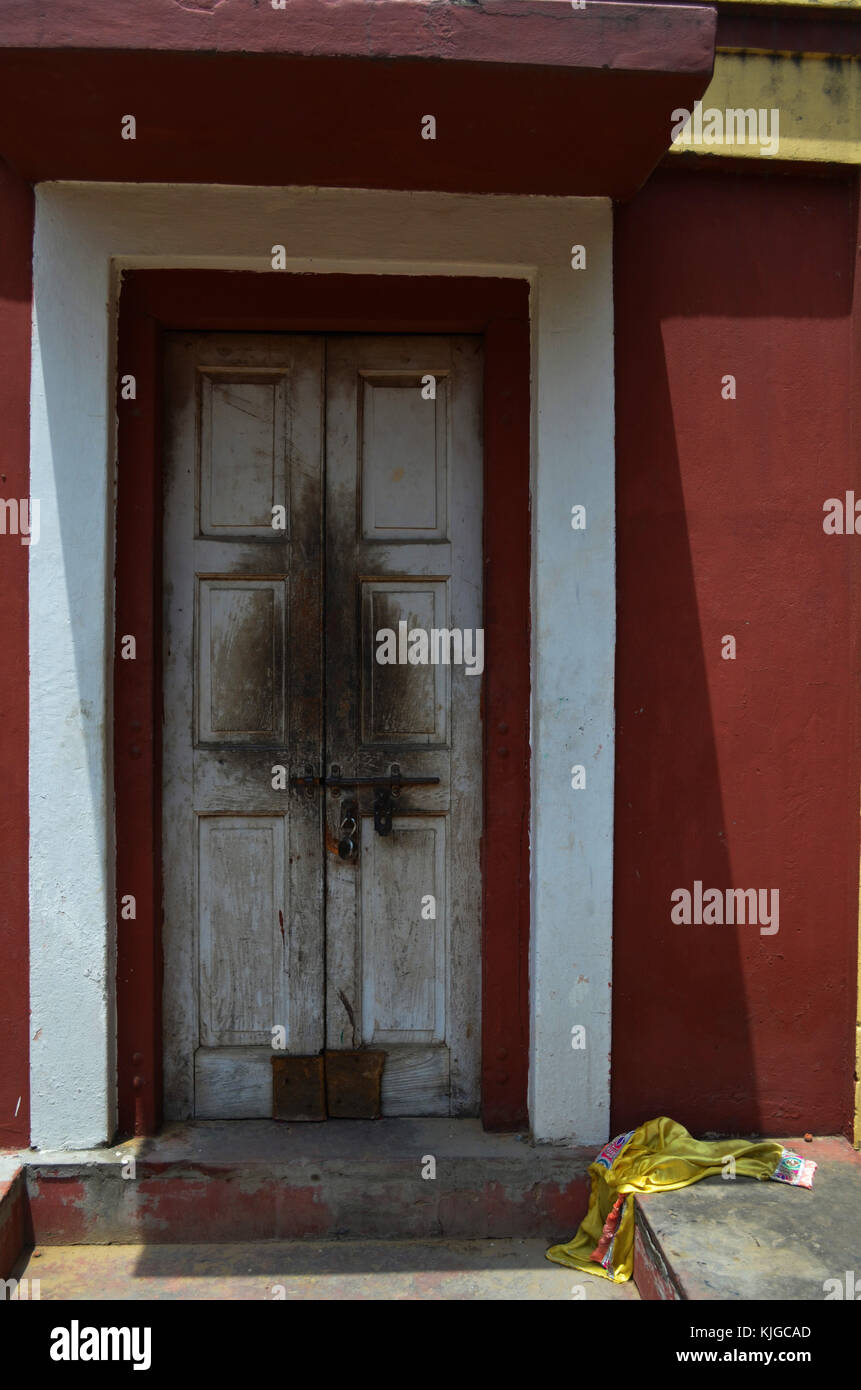 Tür in Stein Tür mit gelben Kopftuch auf dem Boden, am Hindu Tempel in Neu Delhi Indien genommen Stockfoto