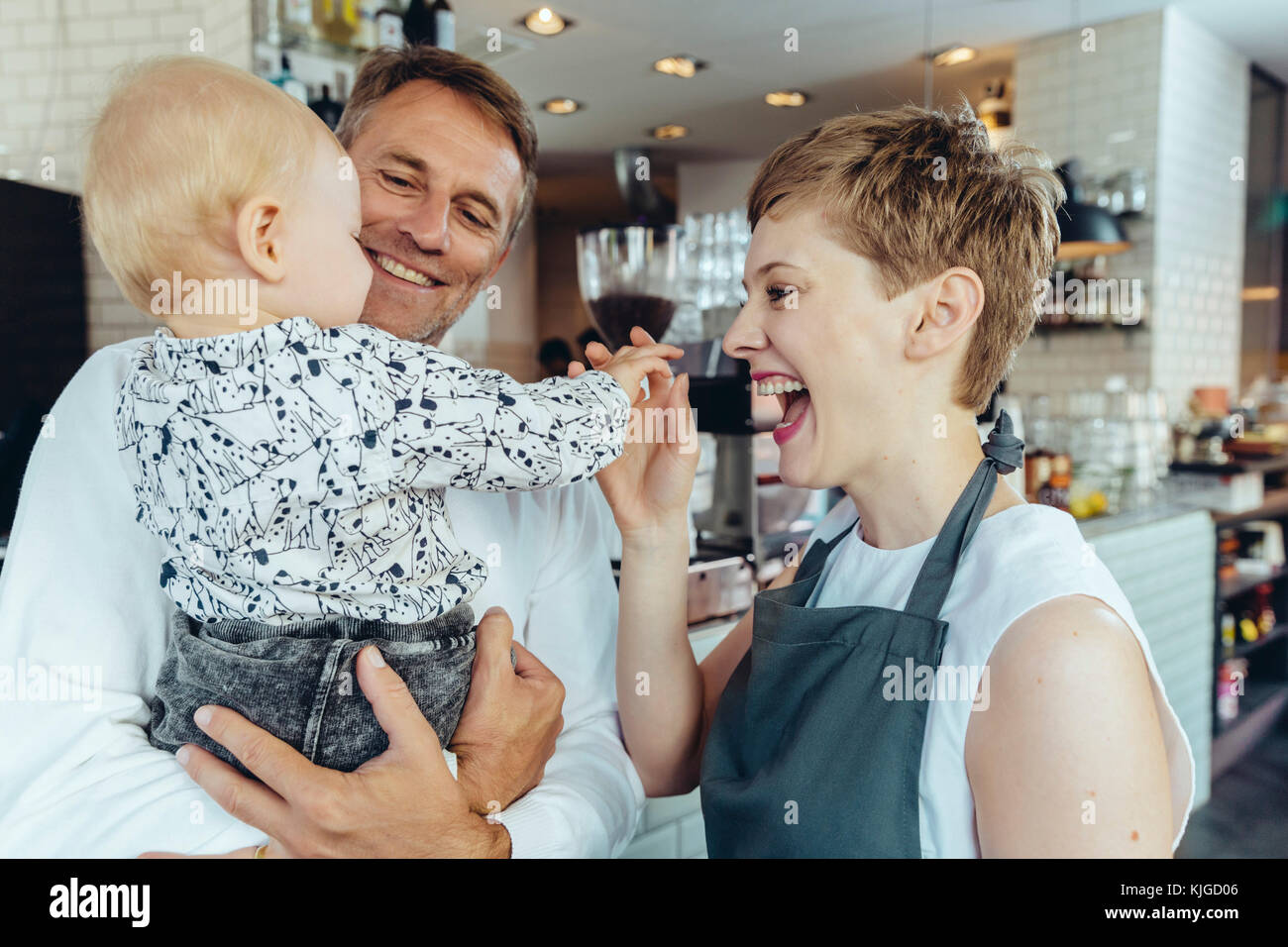 Kellnerin spielt mit Baby von Kunden im Cafe Stockfoto