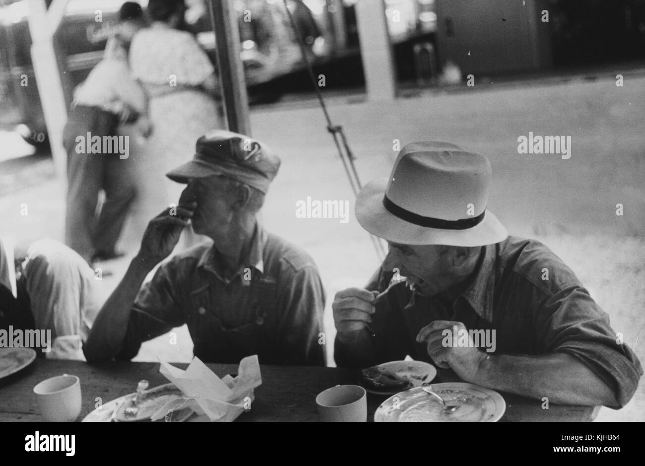 Schwarz-weiß-Foto von Zuschauern auf einer Kreismesse, Essen Mittagessen, von Ben Shahn, gebürtiger Litauer, amerikanischer Künstler, der für seine Arbeit für die Farm Security Administration bekannt ist, die die Auswirkungen der Großen Depression in Ohio, 1938 dokumentiert. Aus der New York Public Library. Stockfoto