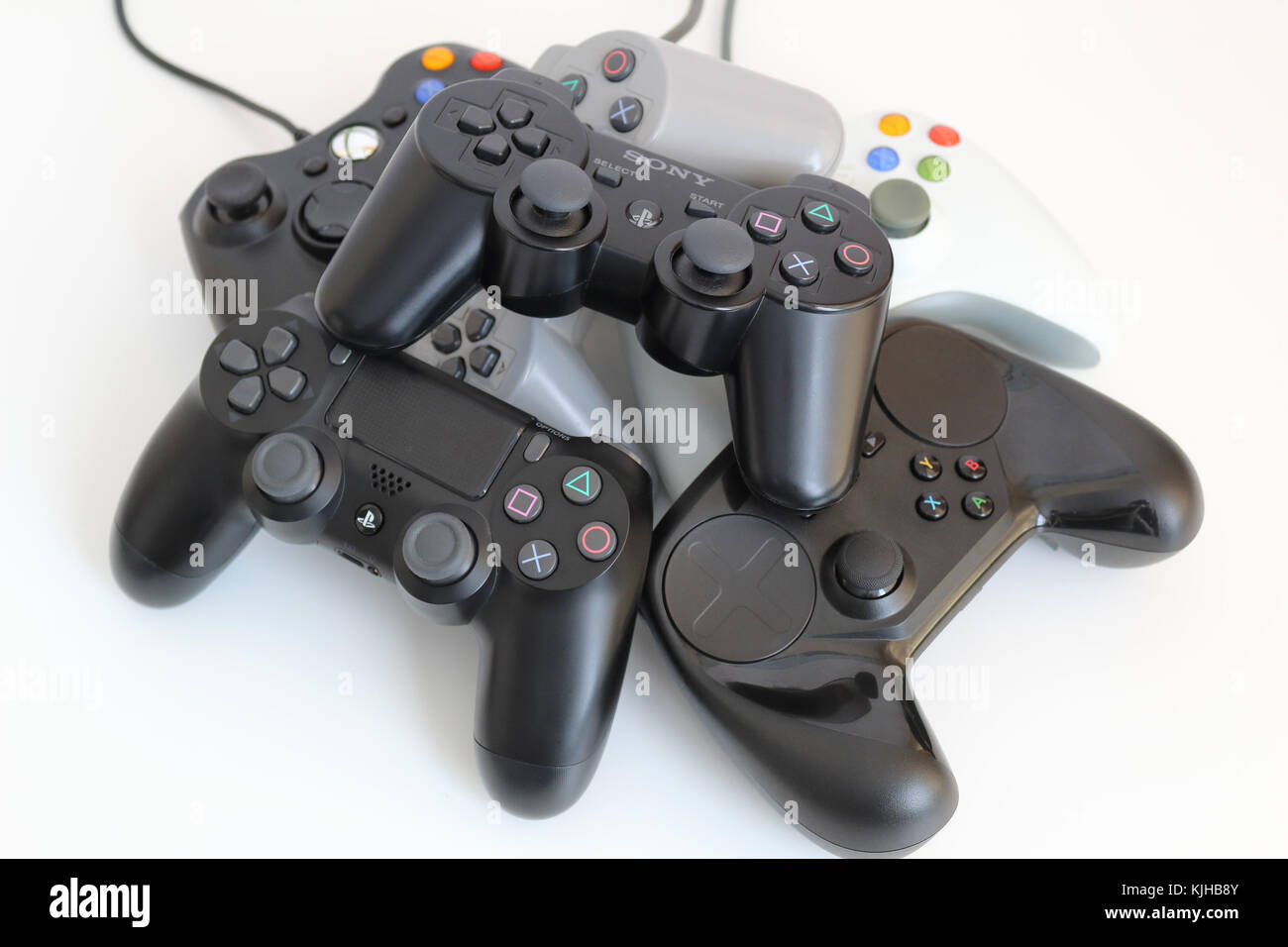 Verschiedene computer game Controller, in einem Stapel auf einem weißen Hintergrund angeordnet. Stockfoto