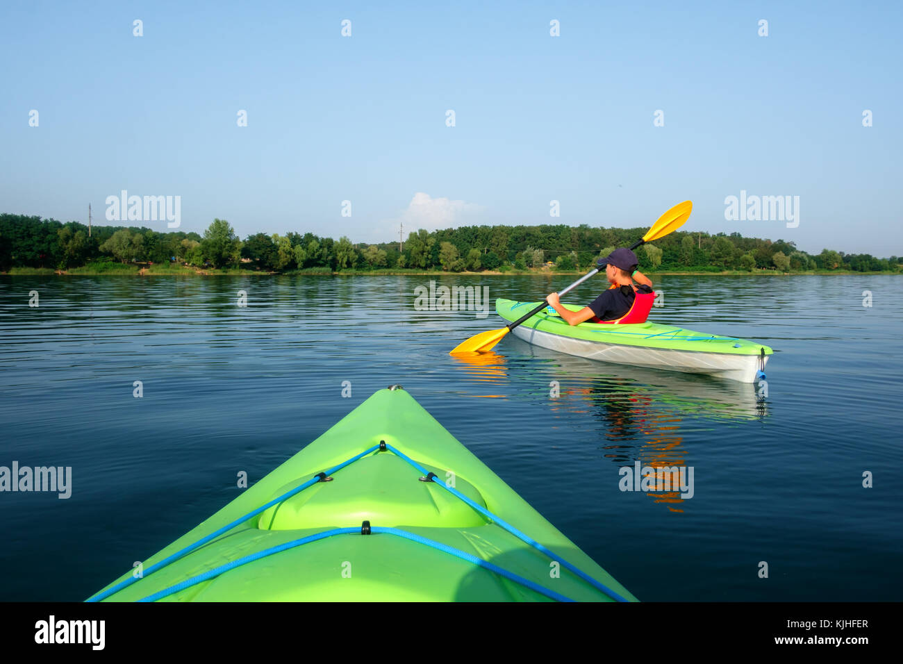 Junge in Schwimmweste auf grün Kajak Stockfoto