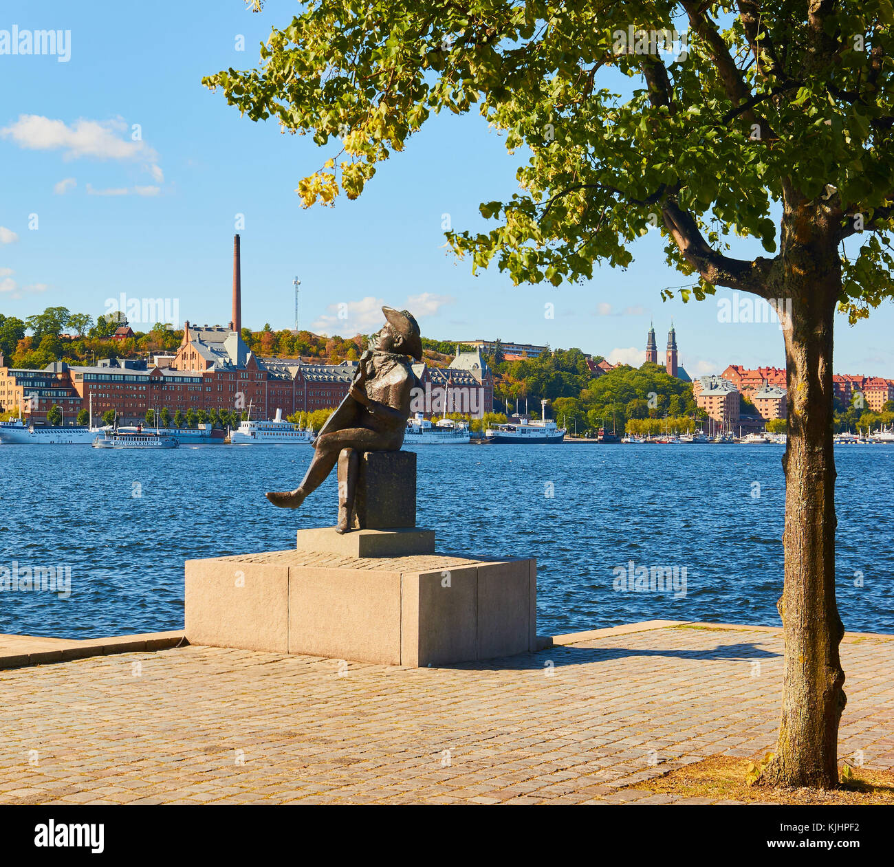 Statue von Evert Taube die Linie Troubadour der Schwedischen Ballade Tradition mit Vorort von Södermalm im Hintergrund, Riddarholmen, Stockholm, Schweden Stockfoto
