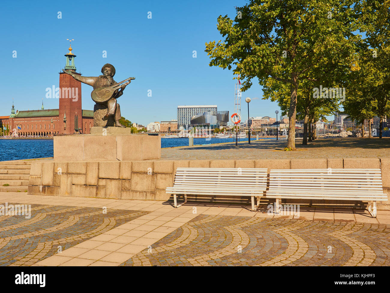Statue von Evert Taube vor allem Troubadour der Schwedischen Ballade Tradition mit Stadshuset (Rathaus) im Hintergrund, Riddarholmen, Stockholm, Schweden Stockfoto