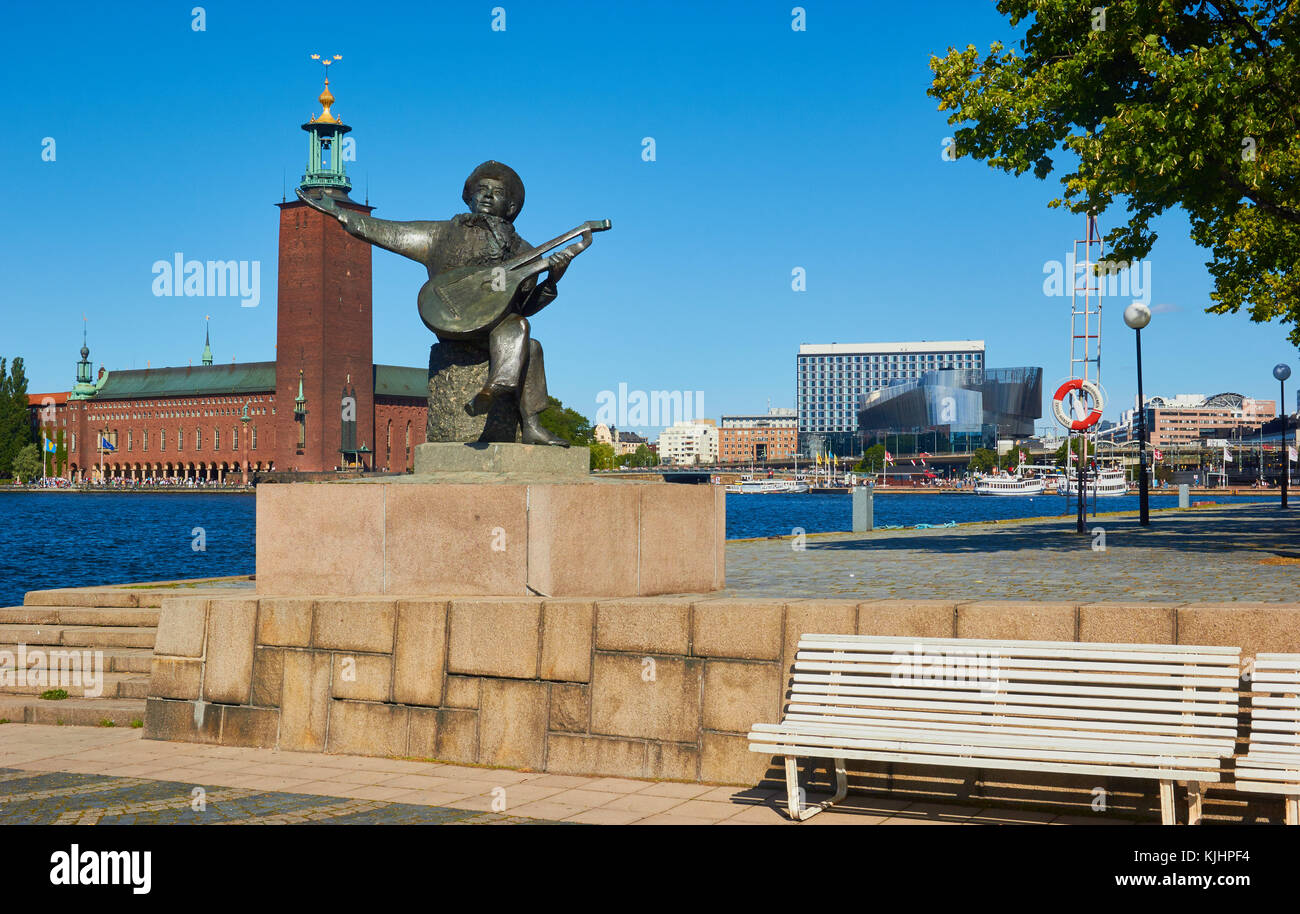 Statue von Evert Taube vor allem Troubadour der Schwedischen Ballade Tradition mit Stadshuset (Rathaus) im Hintergrund, Riddarholmen, Stockholm, Schweden Stockfoto