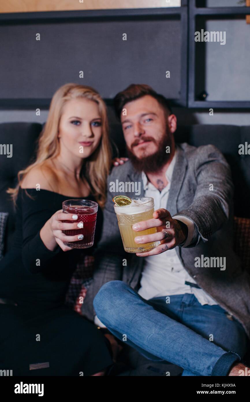 Junger Mann und Frau in einer Bar, eine feierliche Toast sitzen Stockfoto