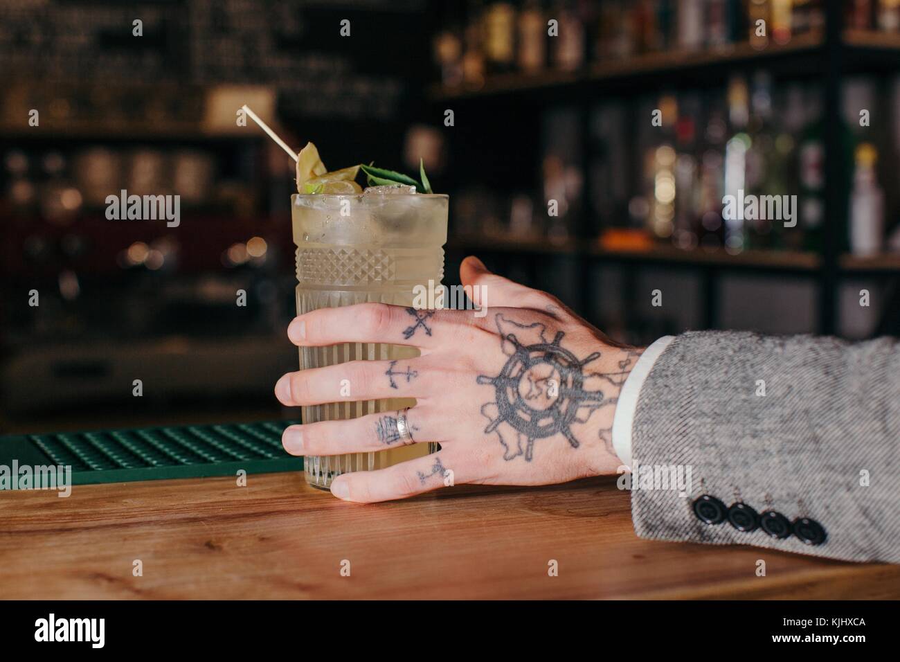 Des Menschen Hand erreichen für einen Cocktail in einer Bar Stockfoto