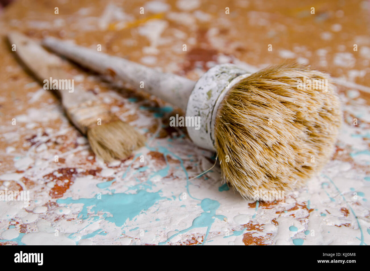 Zwei Bürsten auf einer Hartfaserplatte gebeizt mit Farbe Hintergrund Stockfoto