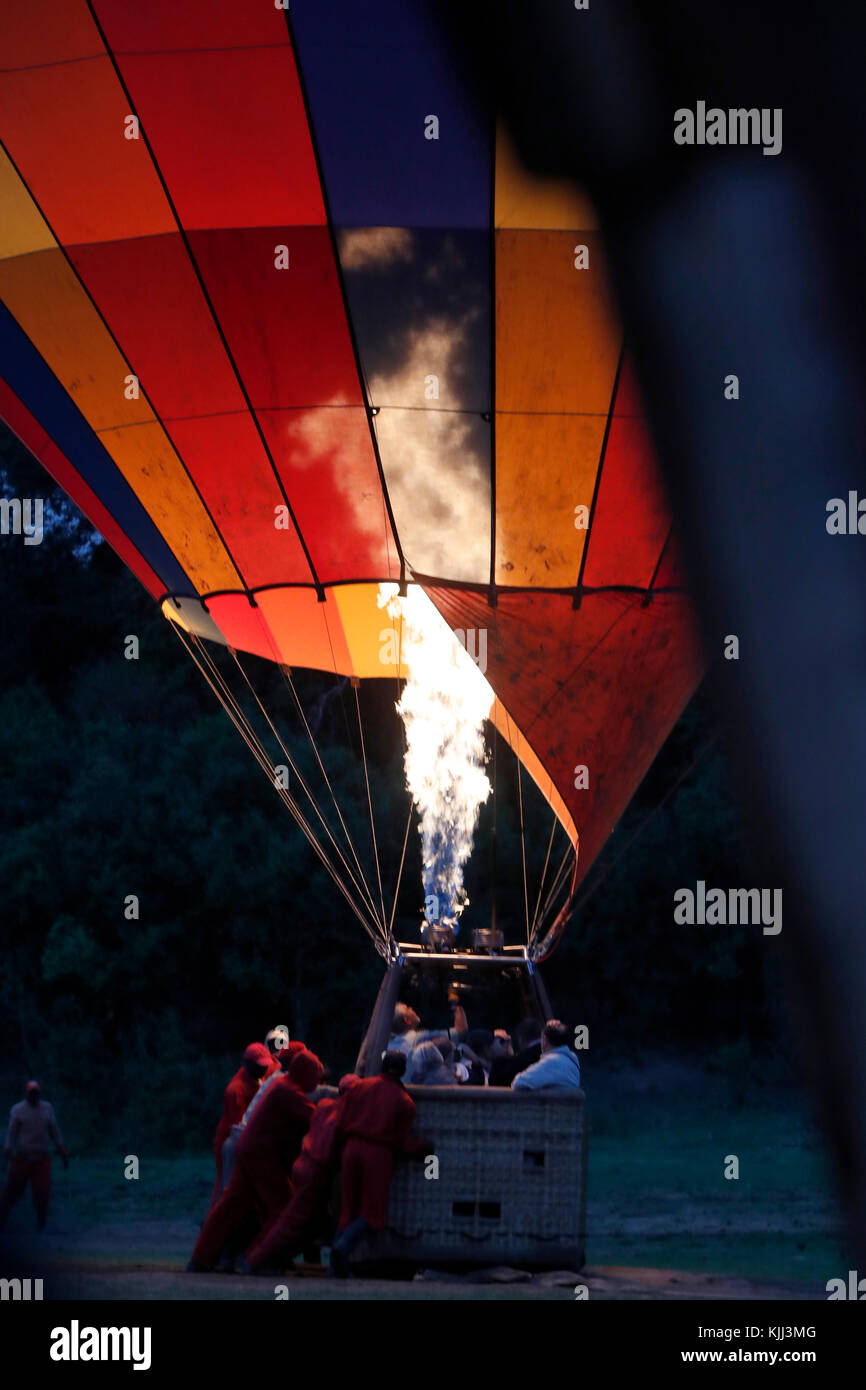 Ein gas jet Flamme füllt ein heissluftballon in der Dämmerung für eine touristische Flug über die afrikanische Savanne. Masai Mara Game Reserve. Kenia. Stockfoto