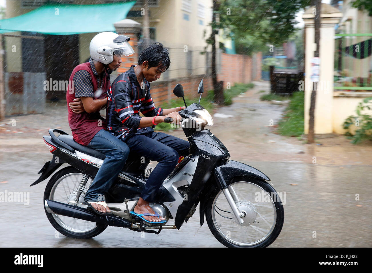 Motorradfahrer im Regen. Kambodscha. Stockfoto