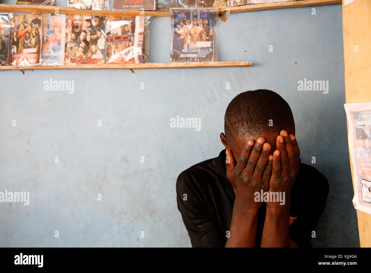 Junger Mann sein Gesicht versteckt. Uganda Stockfoto