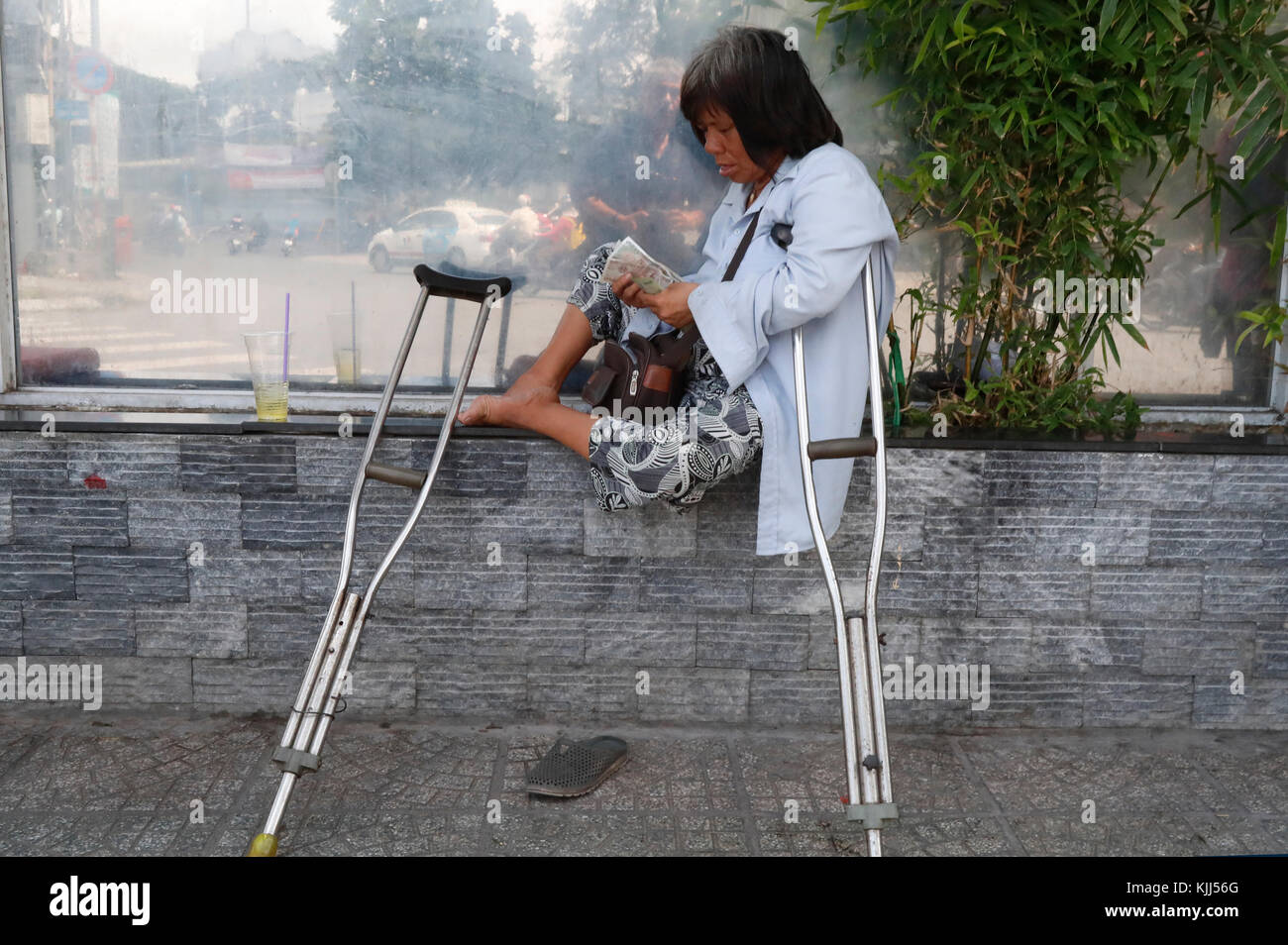 Eine behinderte Frau mit Krücken auf der Straße. Ho Chi Minh City. Vietnam. Stockfoto