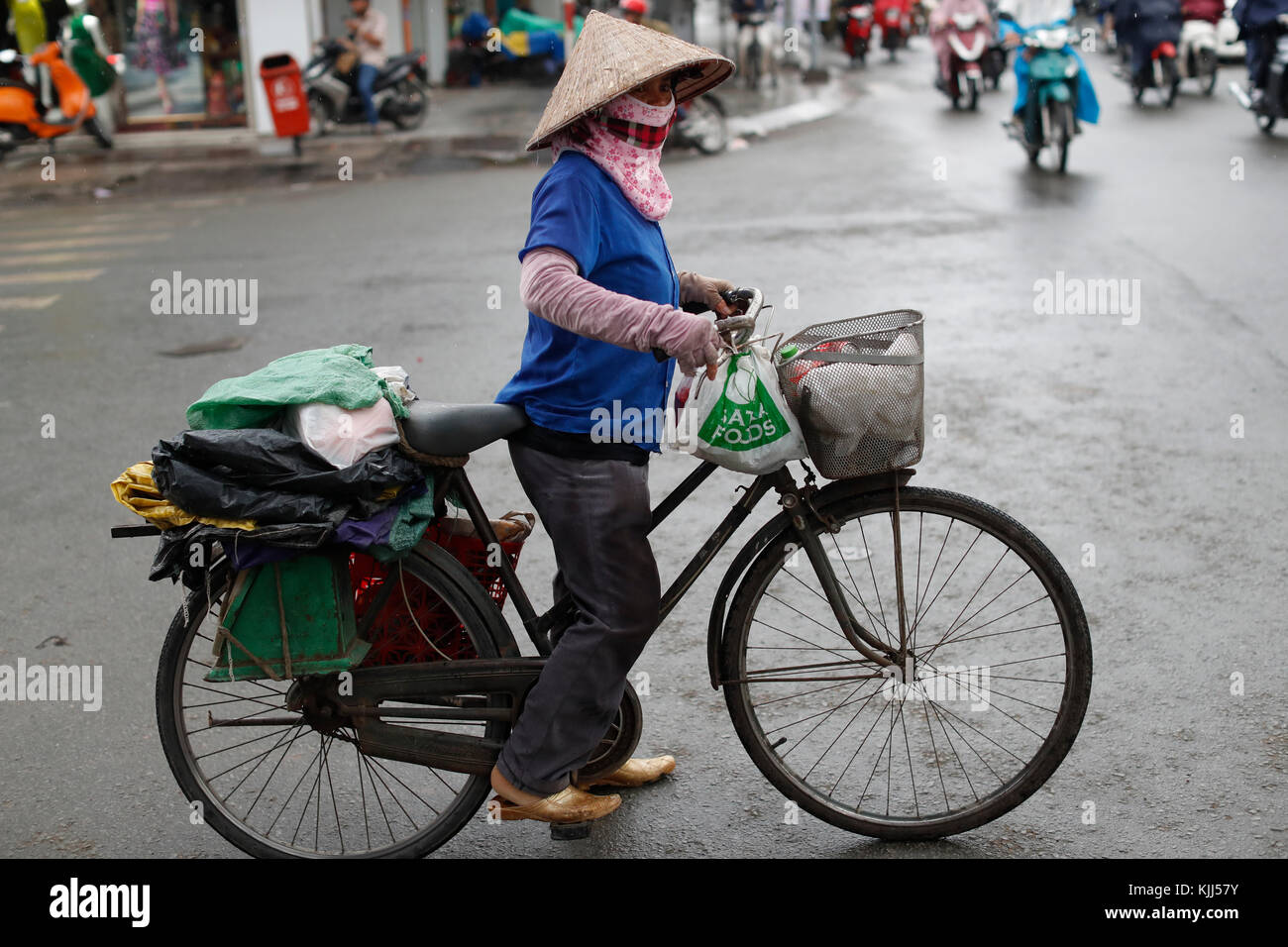 Vietnamesische Frau Reiten Fahrrad auf Saigon Straße. Ho Chi Minh City. Vietnam. Stockfoto