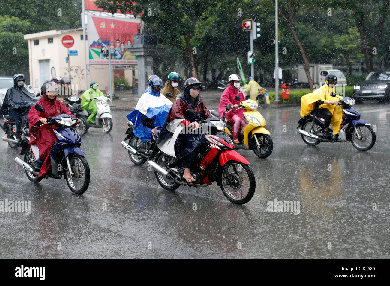 Schwere Monsunregen. Vietnamesische Leute fahren Motorräder auf Saigon Straße. Ho Chi Minh City. Vietnam. Stockfoto