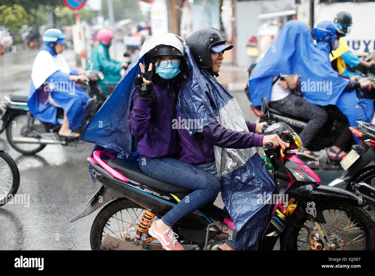 Schwere Monsunregen. Vietnamesische Leute fahren Motorräder auf Saigon Straße. Ho Chi Minh City. Vietnam. Stockfoto
