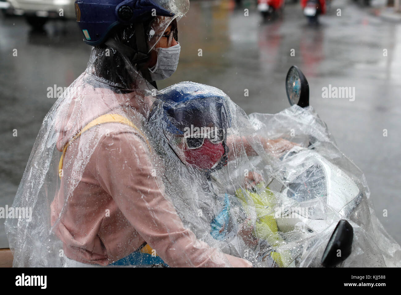 Schwere Monsunregen. Vietnamesische Leute fahren Motorräder auf Saigon Straße. Ho Chi Minh City. Vietnam. Stockfoto