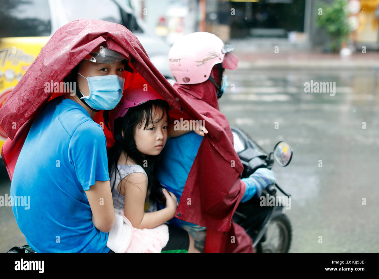 Schwere Monsunregen. Vietnamesische Leute fahren Motorräder auf Saigon Straße. Ho Chi Minh City. Vietnam. Stockfoto