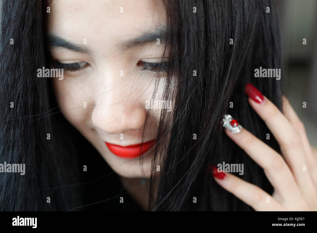 Vietnamesische Frau mit roten Lippenstift und manucure. Ho Chi Minh City. Vietnam. Stockfoto