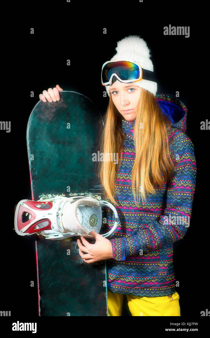 Sportliche Mädchen mit langen blonden Haaren mit Snowboard auf Schwarz studio Hintergrund. Stockfoto