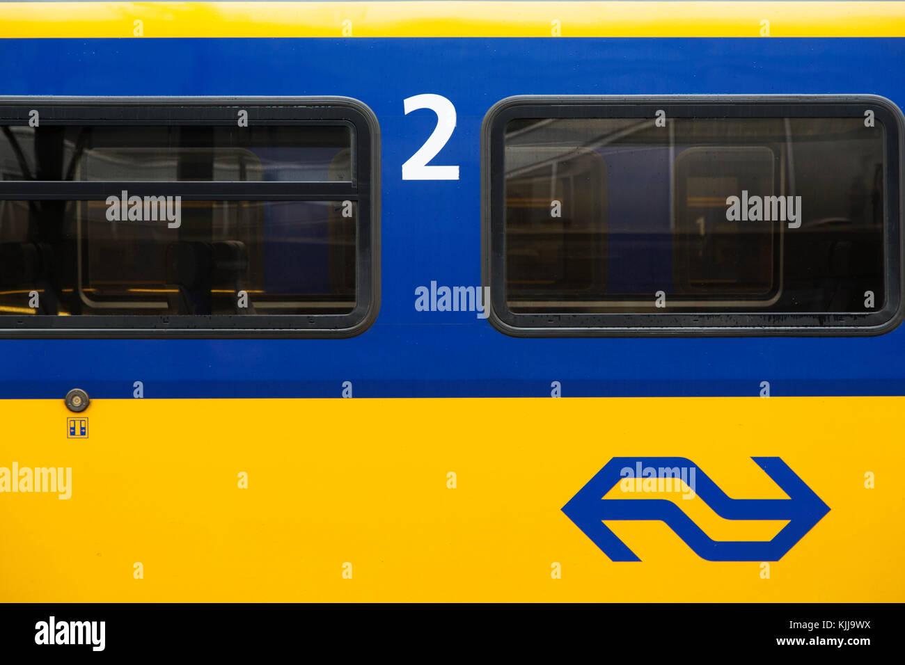 Ein Zug auf der Strecke in Groningen, in den Niederlanden. Sie trägt die gelb-blaue Farbgebung der Firma Nederlandse Spoorwegen (NS). Stockfoto