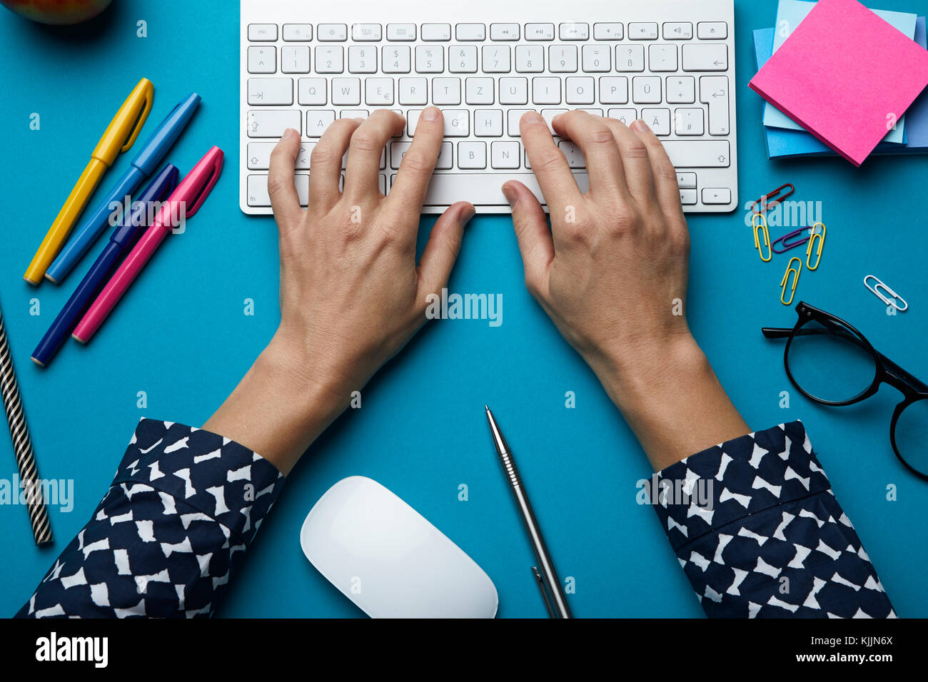 Blick von oben auf die Frau, die Tastatur auf dem Schreibtisch Stockfoto