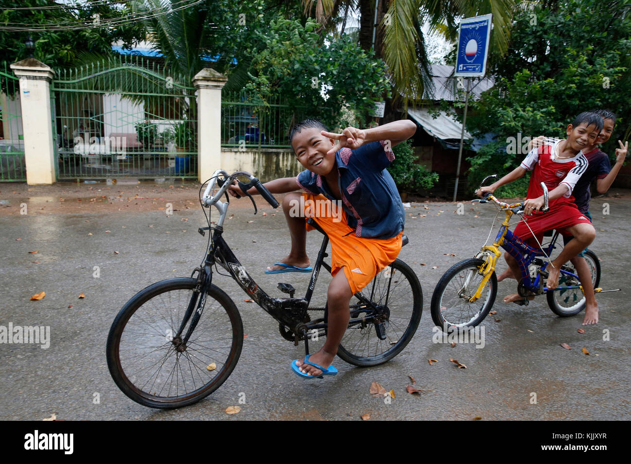 Kinder Radfahren im Regen. Battambang. Kambodscha. Stockfoto