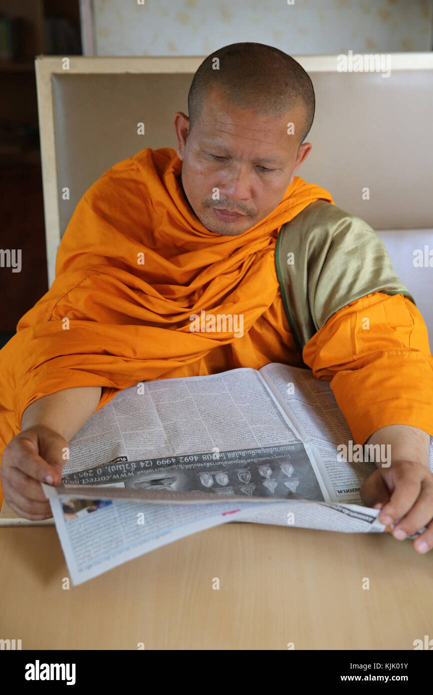 Mönch eine Zeitung lesen in einem Zug. Thailand. Stockfoto