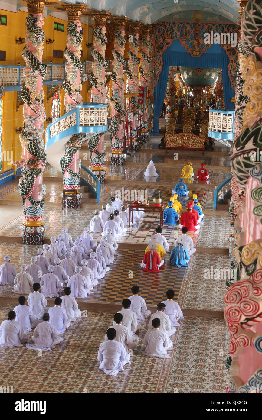 Cao Dai Tempel Heiliger Stuhl. Beten fromme Männer und Frauen, feierliche Mittag Gebet. Thay Ninh. Vietnam. Stockfoto