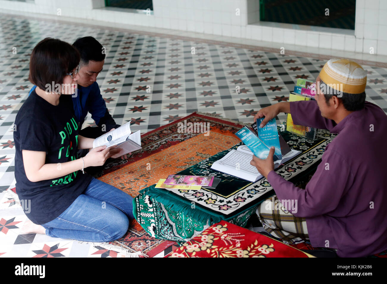 Saigon Zentralmoschee. Muslimischen mann Broschüren geben zu einem jungen Paar. Ho Chi Minh City. Vietnam. Stockfoto