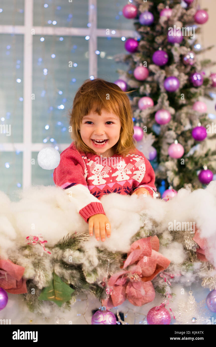 Happy Baby Mädchen spielen mit Schneebällen im Zimmer. Das Mädchen wirft einen Schneeball Stockfoto