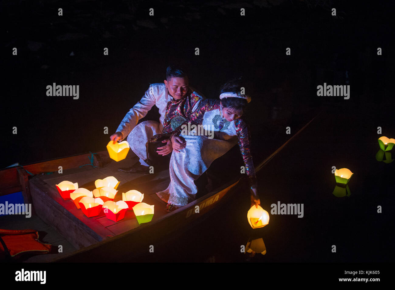 Vietnamesisches Paar lässt Laternen in Hoi An, Vietnam, in den Fluss fallen Stockfoto