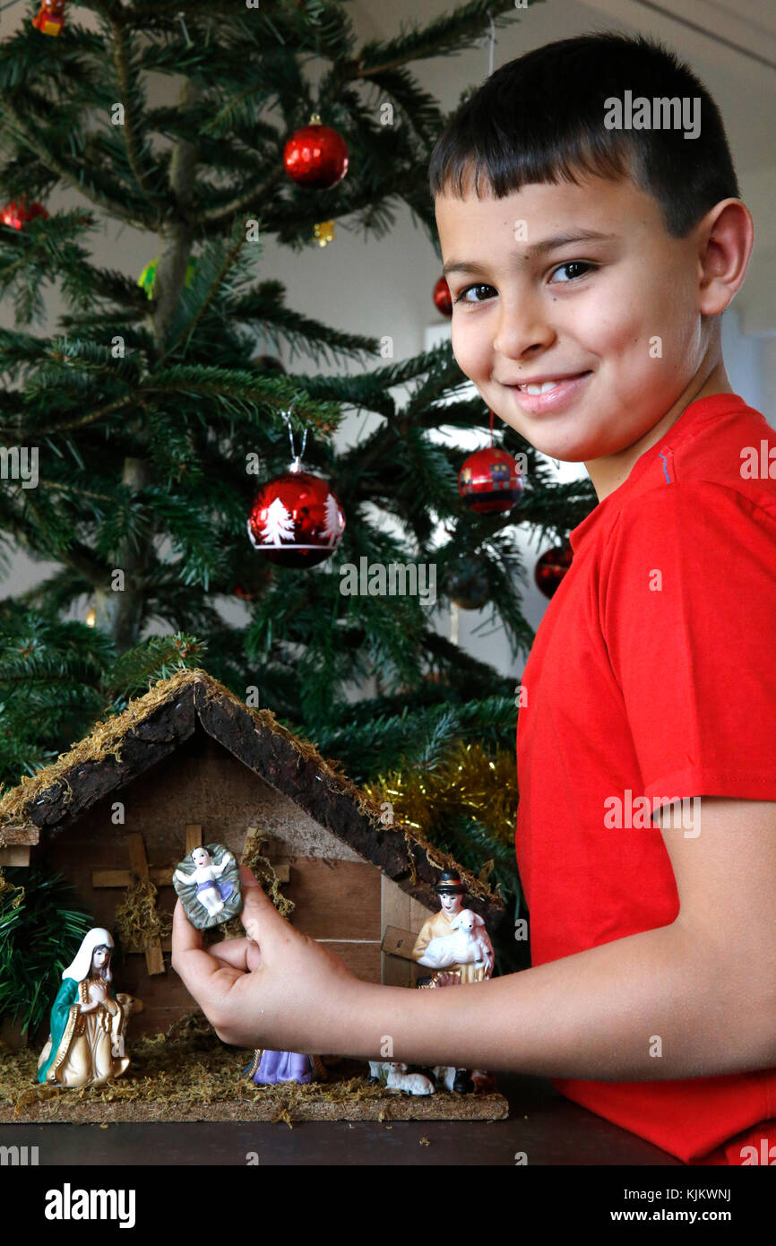 10-Year-Old Boy Verlegung eine Weihnachtskrippe. Frankreich. Stockfoto