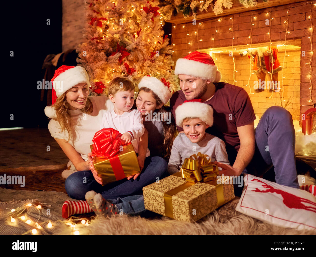Die Familie stellt in einem Zimmer am Weihnachtstag. Stockfoto