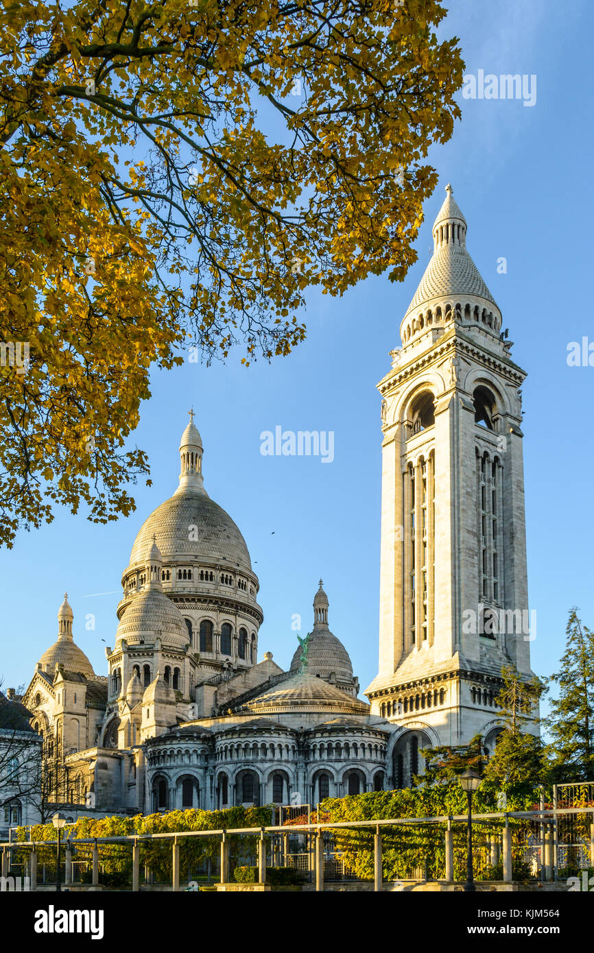 Die Basilika des Heiligen Herzen von Paris bei Sonnenaufgang im Herbst von drei-viertel hinten mit dem quadratischen Turm und Zweige in der foregrou Stockfoto