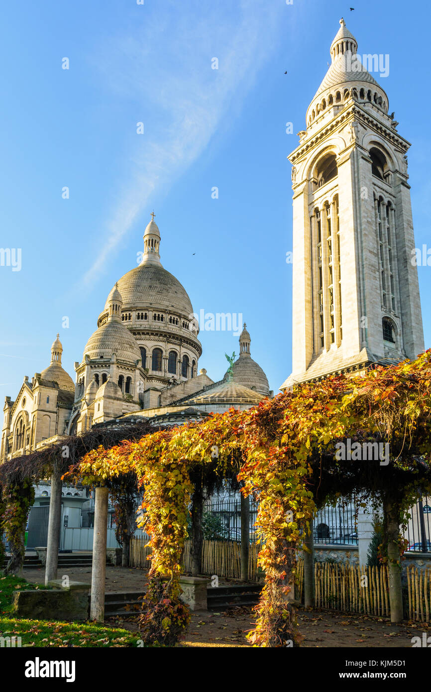 Drei Viertel der Blick auf die Basilika des Heiligen Herzen von Paris bei Sonnenaufgang im Herbst von einem öffentlichen Garten mit Pergola im foregro gesehen Stockfoto